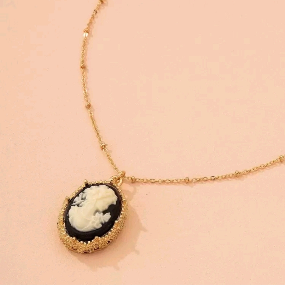 Gold cameo broach with black background